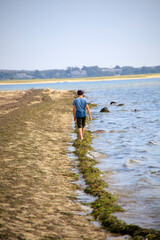 Boy walking on the beach near the ocean