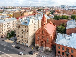 Fototapeta na wymiar Aerial photo of protestant St. John's Church from red bricks. Historical Estonian Lutheran cathedral in center of St Petersburg. Russia in the summer. Russian cities. Place for vacation.