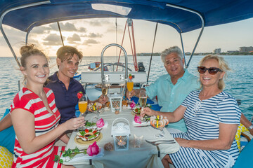 Senior and young couples, family, enjoying sailing trip on a luxury summer holiday vacation, sunny weather and ocean in background, love and romance on a beautiful yacht