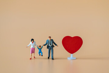 Miniature people Family Father Mother and Children standing near red heart with copy space happiness using for travel around the world business trip traveler adviser agency or valentine day special