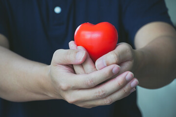 People holding heart shape shape in concept of healthy and heart disease prevention.