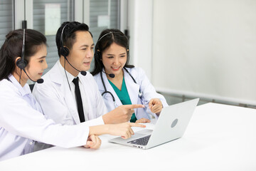 group of doctors talking with colleague through online video chat from laptop computer in hospital