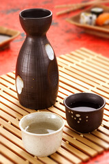 Copos e garrafa de sake em mesa de restaurante japonês - mesa com taça de sake oriental