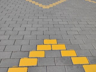 Gray paving slabs with a pattern of yellow tiles