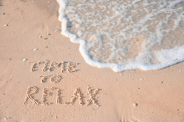 Phrase Time to relax written on sand at beach