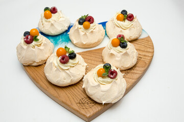 Pavlov's cake. Cakes on a platter. Sweet Dessert. A treat for the guests. Dessert for the holiday. The cake is decorated with berries.