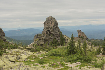large kurum stones lie in the forest in the mountains, stones covered with moss, against the background of the forest, mountain landscape, high in the mountains.