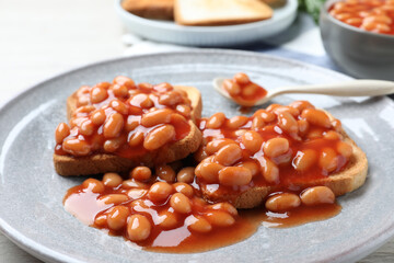 Toasts with delicious canned beans on plate, closeup