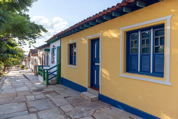 A street of colorful colonial style houses in a village. Stone pavement. Historic city of Pirenópolis, State of Goiás. Brazil. Tourism.