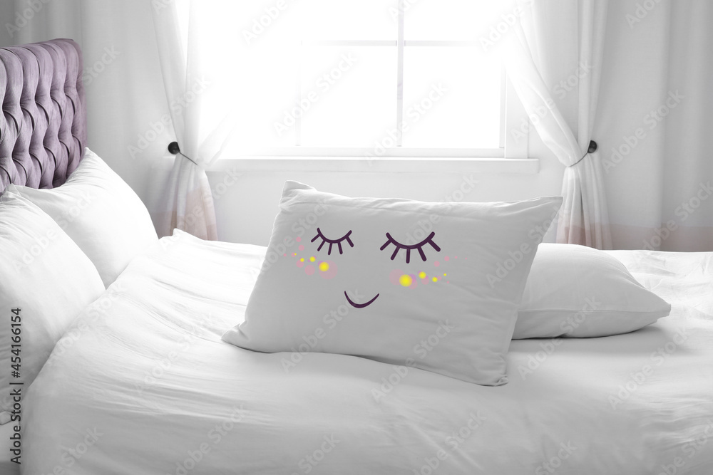 Poster soft pillow with cute face on comfortable bed in room