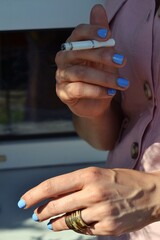 Woman's hands holding a cigarette, smoking kills beauty.