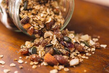 Jar with Granola of Oatmeal, Pecans, Nuts, Oats, Dates, Pine Spread on a Wooden Board 