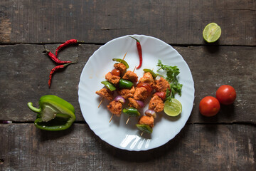 Kebabs or pieces of grilled meat chunks and vegetables on a plate with use of selective focus