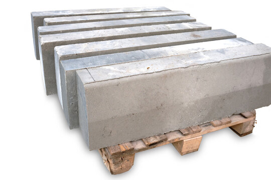 Stack of gray curbstone on pallet standing on pavement. The pallet with a stack of concrete curbstone. Road repairs. A few stacks of curbs prepared for laying. isolated on white background