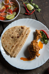 North Indian meal paratha or flat bread served with spicy chicken. Top view. 