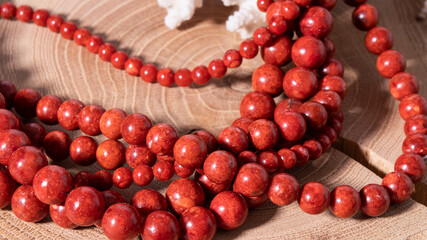 Luxurious natural red and orange coral beads close up on a wooden background. Natural coral. Strong...