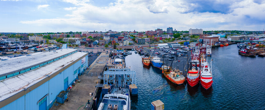 New Bedford harbor panorama aerial view with fishing boats docked at piers and historic downtown of New Bedford at the background, Massachusetts MA, USA. 