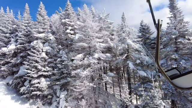 Ski lift winter landscape with snow and trees. Beautiful blue sky weather on pefect day for skiing or snowboarding at ski resort with classic ski chairlift.