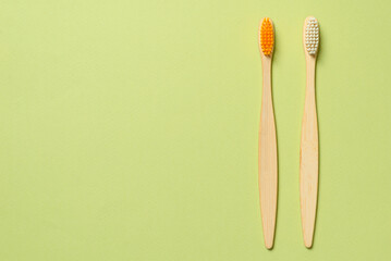 Bamboo toothbrush on a green background.