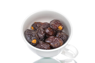 Several royal dates in a white ceramic dish, close-up, isolated on white.