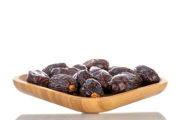 Several royal dates on a bamboo plate, close-up, isolated on white.