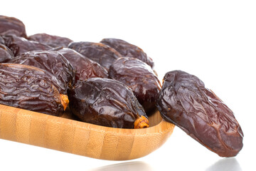 Several royal dates on a bamboo plate, close-up, isolated on white.