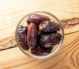 Several royal dates in glassware on a wooden table, close-up, top view.