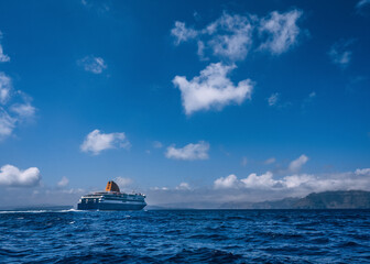 Cruise ship near Santorini island in Aegea sea, Greece. Ferry sailing to port. Transportation by...