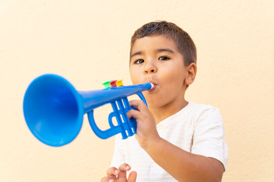 Cute child with blue toy trumpet