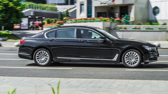 Black BMW 7 Series G12 car moving on the street. Compliance with speed limits on road concept. Dynamic exterior image