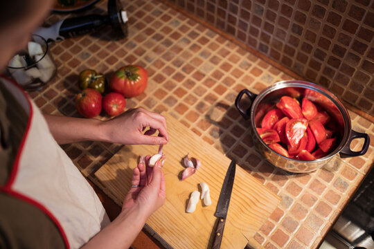 woman cutting garlic in kitchen