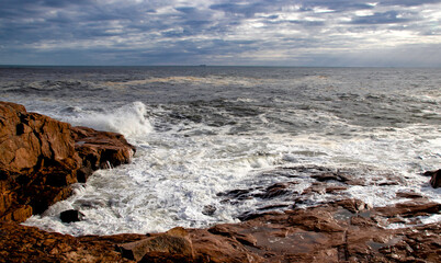 Fototapeta na wymiar Waves crashing on rocky shore.
