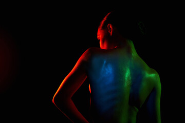 Female back silhouette, beautiful woman in color lights. Art design, colorful girl with radiance...