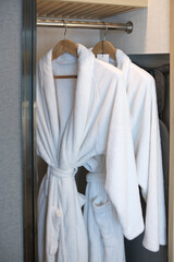 white bathrobe with wooden hangers in the wardrobe.