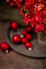 Red Hydrangeas in a Silver Vase with Red Christmas Balls Out of Focus in Background