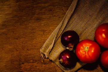 Fresh tomatoes and onions on rustic background