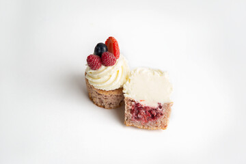Pastry chef's hand straightens berries on a cake