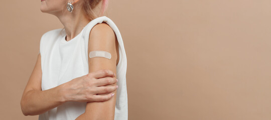 Young hipster woman with band aid after coronavirus Covid-19 vaccine injection. Covid vaccination...