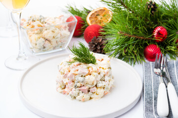 Traditional New Year's salad olivier with festive decorations on a white background