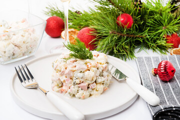 Traditional New Year's salad olivier with festive decorations on a white background
