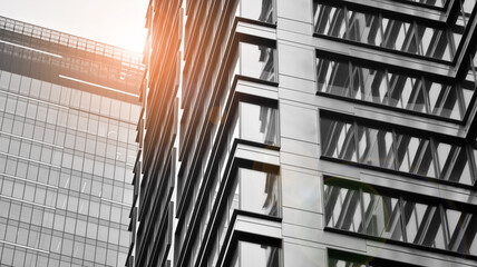 Modern architectural details. Modern glass facade with a geometric pattern. Contemporary corporate business architecture. Red sun on horizon. Black and white toned image.