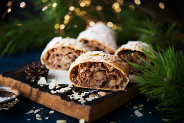 Homemade Christmas dessert, apple strudel, cake on the festive table with garlands
