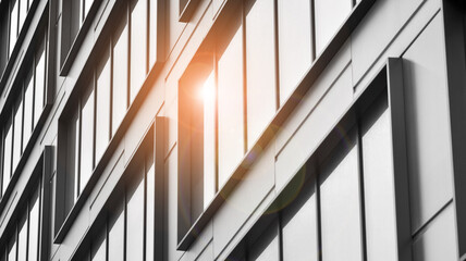 Modern architectural details. Modern glass facade with a geometric pattern. Contemporary corporate business architecture. Red sun on horizon. Black and white toned image.