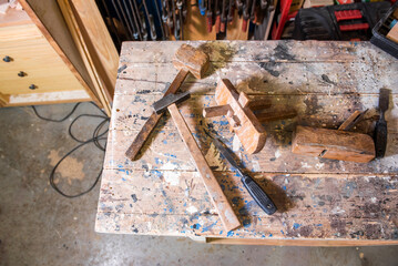 The tools of a carpenter on a work table in a carpentry workshop. Hammer, wood brush, rasp,