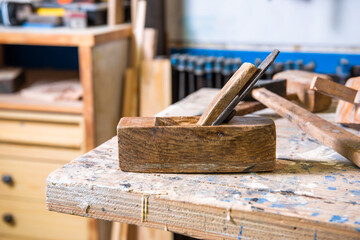 The tools of a carpenter on a work table in a carpentry workshop. Hammer, wood brush, rasp,