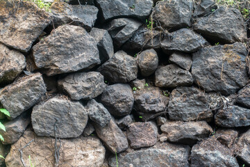 Wall made of black stones, background, wallpaper