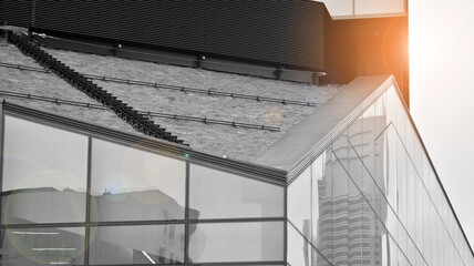Fototapeta premium Modern architectural details. Modern glass facade with a geometric pattern. Contemporary corporate business architecture. Red sun on horizon. Black and white toned image.