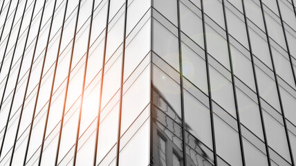 Modern architectural details. Modern glass facade with a geometric pattern. Contemporary corporate business architecture. Red sun on horizon. Black and white toned image.