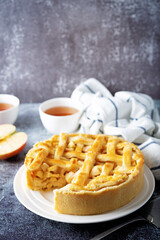 Apple cake with fresh apple slices and cups of tea