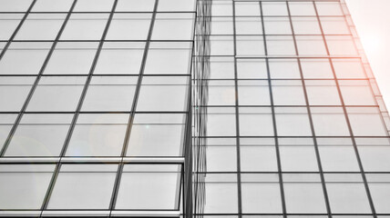 Modern architectural details. Modern glass facade with a geometric pattern. Contemporary corporate business architecture. Red sun on horizon. Black and white toned image.